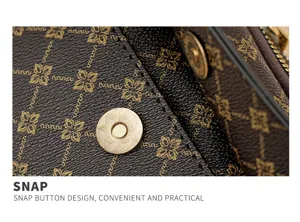 Detailed view of women's brown monogram crossbody bag with convenient gold snap button.