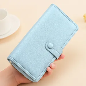 Nahaufnahme Detail der hellblauen langen Damenbrieftasche mit Druckknopf und Reissverschluss.