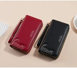 Close-up detail of long PU leather zip wallets with cute cat pattern and handy wrist strap.