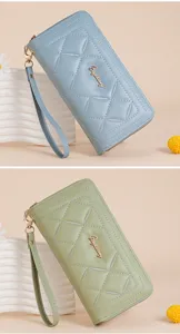 Detailed view of women's quilted long wallet clutch with zipper closure and wrist strap.