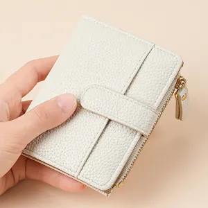 Close-up of the white leather bifold wallet featuring multiple card slots and zip coin pocket.
