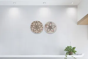 Close-up detail of natural seagrass woven hanging plates displayed on a clean white wall.