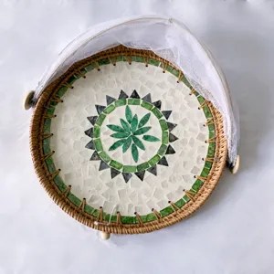 Handcrafted rattan basket detail showing colorful shell mosaic and white mesh dome cover.