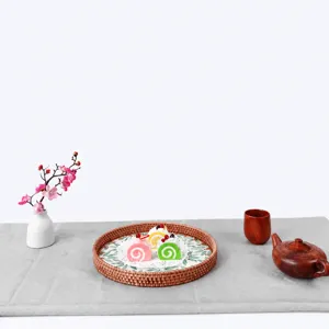 Round woven rattan tray with shell leaf pattern detail, perfect for serving tea or snacks.
