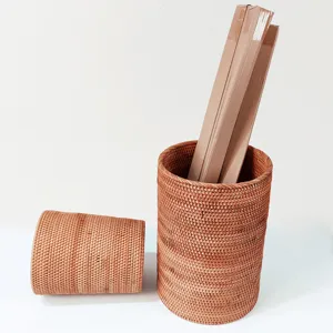 Detail view of natural rattan woven storage bucket and round basket for organizing scrolls.