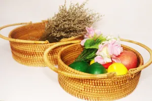 Handwoven rattan fruit basket detail showing natural woven texture, oval shape and sturdy handles.