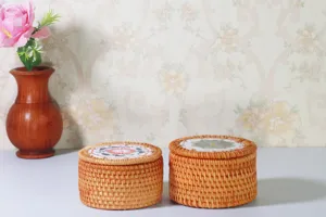 Scatola portaoggetti rotonda in rattan intrecciato con coperchio, ideale per tè e caramelle.