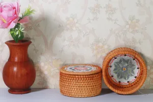 Dettaglio della scatola portaoggetti in rattan intrecciato a mano con texture naturale e base.