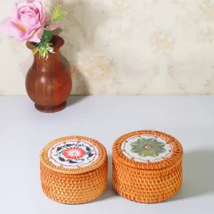 Scatola di immagazzinaggio rotonda in vimini intrecciato con coperchio in ceramica per tè.