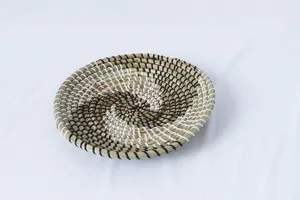 Vista dettagliata del piatto intrecciato in erba marina naturale con motivo a spirale.