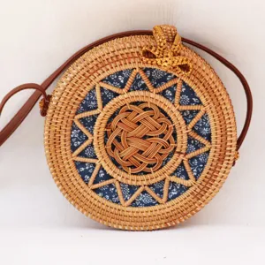 Sac bandoulière rond en rotin tressé style rétro avec doublure florale pour femmes.
