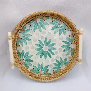 Ronde rotan dienblad met schelp en groene bladeren patroon, bovenaanzicht presentatie.