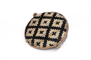 Gedetailleerde close-up van de handgewoven bamboe netmand met zwart en natuurlijke geometrische patronen.