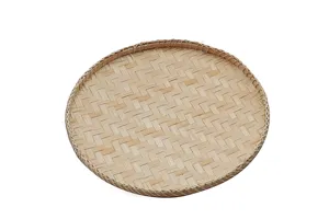 Vue détaillée d'un plateau tamis tissé en bambou naturel, vaisselle de cuisine rustique.