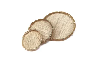 Detalle en primer plano de bandejas redondas de bambú natural tejido con finura.