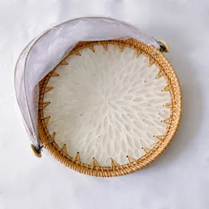 Handmade rattan fruit basket detail with shell inlay and mesh cover for home kitchen use.