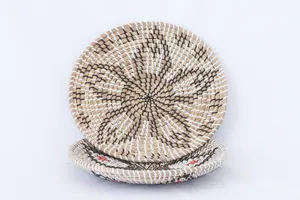 Detail view of handmade seagrass woven decorative hanging plate with natural geometric patterns.