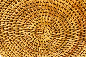 Gros plan détaillé de la texture en rotin tissé naturel avec un motif spiralé fin.