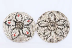 Seagrass woven decorative hanging plate, handmade floral pattern round art wall decor piece.