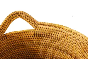 Vue détaillée de la poignée du panier en rotin tissé, montrant une texture fine et serrée.