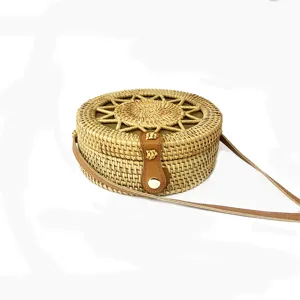 Ronde geweven rotan crossbody tas met lederen band en drukknoop voor strand en vakantie.