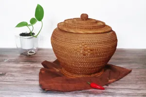 Vue détaillée du pot de stockage de thé en rotin tissé fait main sur surface en bois