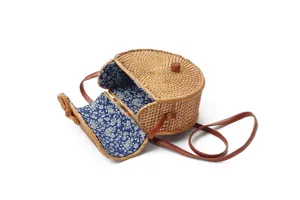 Handcrafted round rattan wicker straw crossbody shoulder bag with floral fabric lining.