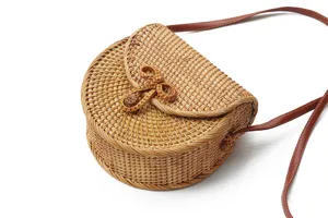 Handmade woven rattan shoulder bag detail showing natural texture and retro bow clasp design.