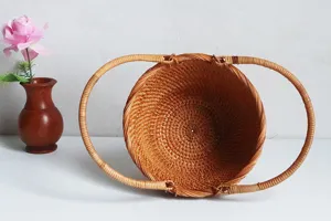 Vietnamese handmade round rattan woven fruit basket detail view, desktop storage container.