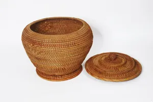 Gros plan detaille de la texture du pot a the en rotin tisse et du couvercle structure.