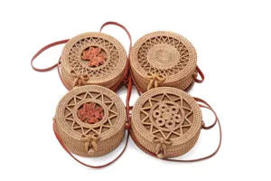 Detailed view of round rattan shoulder bags with various woven patterns and cute bow accents.