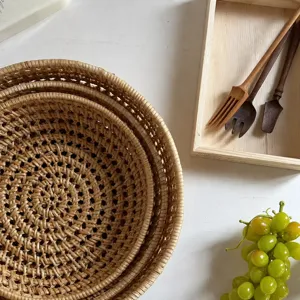 Primo piano dettagliato di piatti in rattan intrecciato a mano impilati in stile naturale.