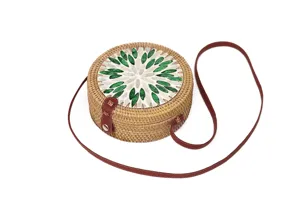 Nahaufnahme der handgeflochtenen Rattan-Umhängetasche mit grün-weißem Muschel-Blumenmuster.