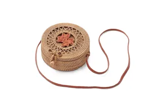 Detailed view of round rattan woven straw bag texture, cute bow and leather strap.