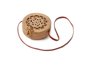 Round woven rattan handbag detail view showcasing natural straw texture and bow accent.
