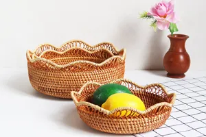 Vista dettagliata del cestino per frutta in rattan intrecciato a mano con bordo sagomato.