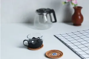Handmade natural woven rattan coaster detail view, eco-friendly heat insulation tea mat.