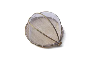 Detalle de cesta de bambú tejida con malla blanca, ideal para secar alimentos y protegerlos.