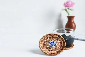 Handcrafted round rattan coaster with blue porcelain center, heat resistant tea mat detail shot.