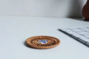 Handmade woven rattan coaster with blue white ceramic center, perfect for tea cups and pots.