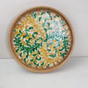Vista di dettaglio del vassoio in rattan artigianale con motivo a mosaico di foglie di conchiglia.