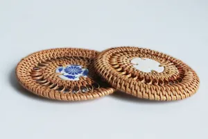 Handcrafted round woven rattan coaster with ceramic insert, perfect for tea cup and hot pot insulation.