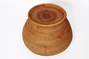 Gros plan détaillé sur le panier de rangement en rotin tissé à la main, texture fine.
