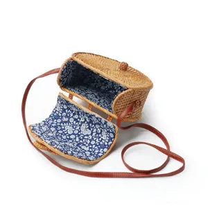 Handwoven round rattan straw shoulder bag with floral lining and brown leather strap casual daily purse.