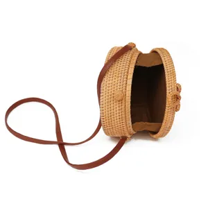 Ronde rattan stro crossbody tas met bruine lederen riem voor zomerse strandvakantie dames.