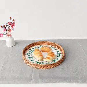 Detailed shot of round woven rattan tray with shell leaf pattern, natural homeware item.