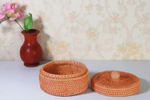 Round woven rattan storage box with lid, detailed view for desktop organization and storage.