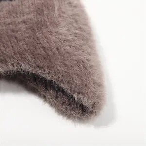 Braunes flauschiges Winter Strickmuetze Detail im Nahbereich, weich und warm fuer kalte Tage.