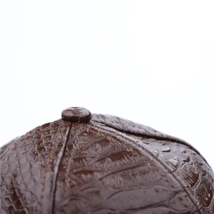 Bruine krokodillenleer hoed detail, close-up textuurweergave, premium mode-accessoire.