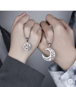 Detailed close-up view of matching sun and moon hollow couple titanium steel necklaces set.